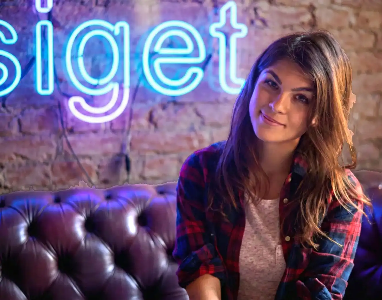 A young woman with long hair smiles confidently for an outdoor portrait session.